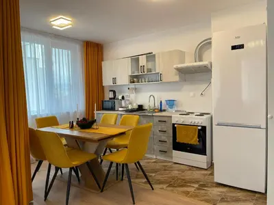 a kitchen with a table and chairs and a white refrigerator at Sofia City Quiet Retreat in Sofia