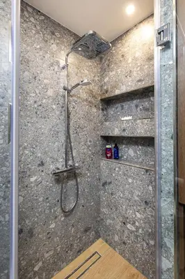 a shower in a bathroom with a stone wall at Two Stylish 1BD Apartments with Desk in Karshiaka by Flat Manager in Plovdiv