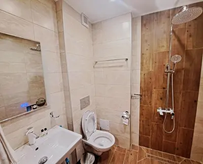a bathroom with a shower and a toilet and a sink at Хотел Ресторант Ваката in Teteven