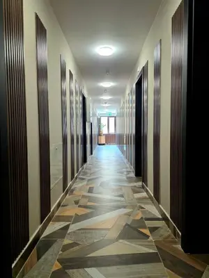 a hallway with a tile floor in a building at Хотел Ресторант Ваката in Teteven