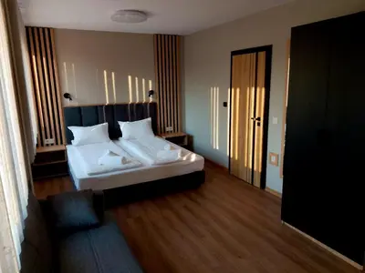a bedroom with a white bed in a room at Хотел Ресторант Ваката in Teteven