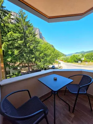 a table and chairs on a balcony with a view at Хотел Ресторант Ваката in Teteven