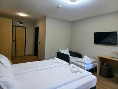 a hotel room with two beds and a flat screen tv at Хотел Ресторант Ваката in Teteven
