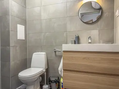 a bathroom with a toilet and a sink and a mirror at 1BR Apartment with a Designated Workspace, Free Street Parking and Free Gym Pass in Plovdiv