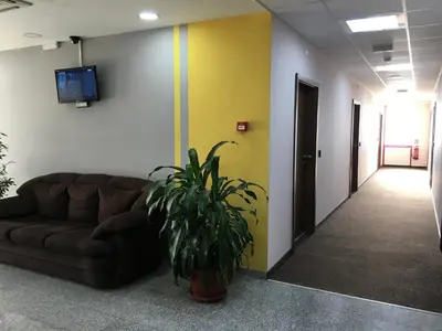 a living room with a couch and a tv on a wall at Hotel Iris in Plovdiv