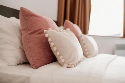 a group of pillows sitting on top of a bed at Pavlina Guest House in Tsŭrvishte
