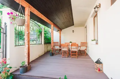 a porch with a table and chairs on it at Pavlina Guest House in Tsŭrvishte