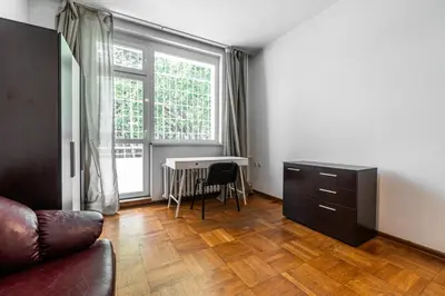 a living room with a couch and a desk and a window at Sofique 3BR in Sofia