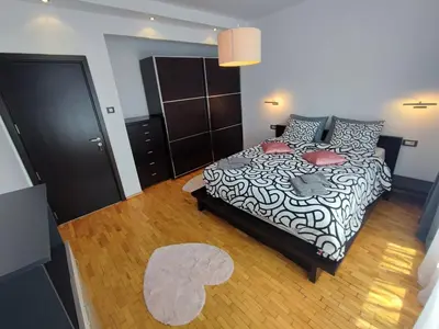 a bedroom with a black and white bed and a rug at Simply The Best - Vitosha blvd in Sofia