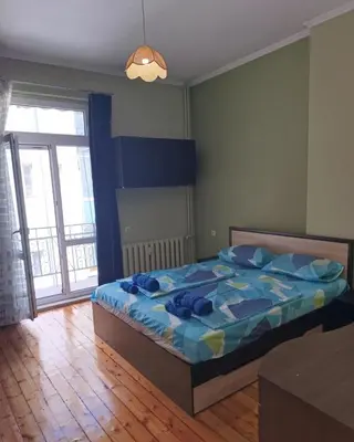 a bedroom with a bed with a blue comforter at Vinchenco and G Suites in Sofia