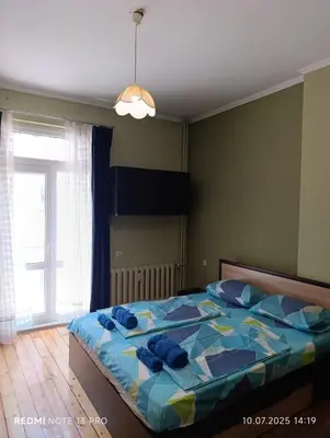 a bedroom with a bed with blue pillows on it at Vinchenco and G Suites in Sofia