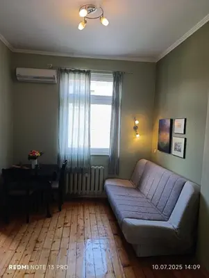 a living room with a couch and a table and a window at Vinchenco and G Suites in Sofia