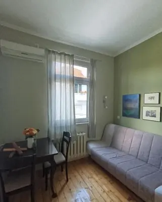 a living room with a couch and a table at Vinchenco and G Suites in Sofia