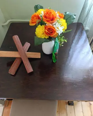 a cross and a vase of flowers on a table at Vinchenco and G Suites in Sofia