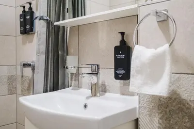a bathroom with a sink and a bottle of soap at А17 Plovdiv Apartments - Next to Rowing Channel and University hospitals in Plovdiv