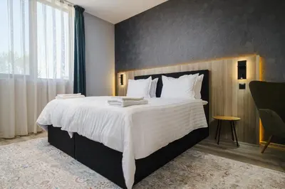 a bedroom with a large bed with white sheets at А17 Plovdiv Apartments - Next to Rowing Channel and University hospitals in Plovdiv