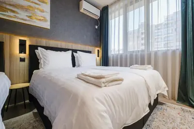 a bedroom with a large white bed with towels on it at А17 Plovdiv Apartments - Next to Rowing Channel and University hospitals in Plovdiv