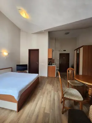a bedroom with a bed and a table and a dining room at Borovets Violet by Ski slopes in Borovets