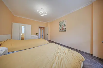 a bedroom with two beds and a ceiling fan at Oranssi Sunset - Free Parking in Sofia