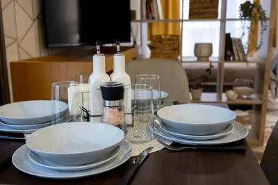 a wooden table with white plates and bottles on it at Good Mood Apartments & Parking in Plovdiv