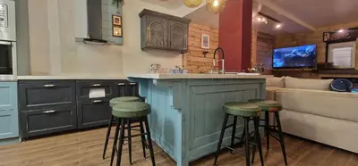 a kitchen with a bar with stools and a couch at Boutique Apartment Katerina in Bansko