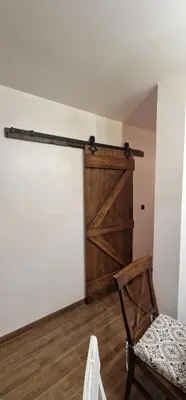 a room with a sliding barn door and a chair at Boutique Apartment Katerina in Bansko
