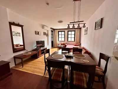 a living room with a table and a dining room at Beby's Apartment - Tamplier in Bansko