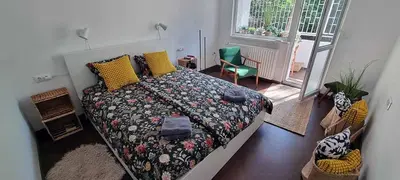 a bedroom with a bed with a flowered comforter at Appartement vintage près de l'Académie de Medecine in Sofia