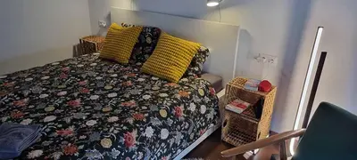 a bedroom with a bed with a comforter and two baskets at Appartement vintage près de l'Académie de Medecine in Sofia