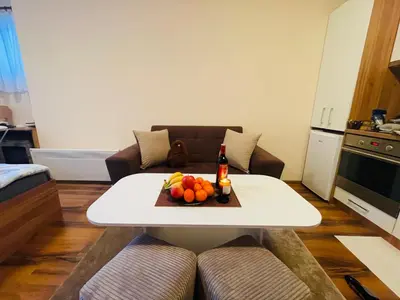 a living room with a table with a bottle of beer and fruit at Studio Harmony, Pamporovo in Pamporovo