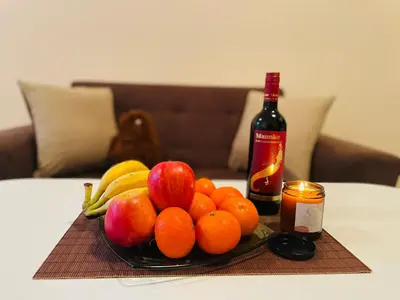 a plate of fruit on a table with a bottle of wine at Studio Harmony, Pamporovo in Pamporovo