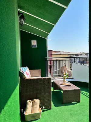 a balcony with chairs and tables on a green wall at Studio with TERRACE - city center in Plovdiv