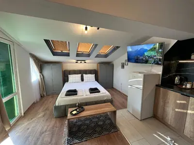 a bedroom with a bed and a flat screen tv at Studio with TERRACE - city center in Plovdiv