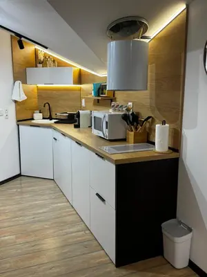 a kitchen with white cabinets and a microwave at Уютни планински апартаменти с басейн в комплекс Алпин Лодж in Bansko