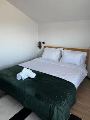 a bed with two towels sitting on top of it at Уютни планински апартаменти с басейн в комплекс Алпин Лодж in Bansko