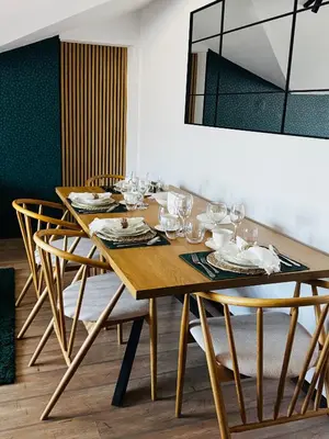 a wooden table with chairs and a dining room at Уютни планински апартаменти с басейн в комплекс Алпин Лодж in Bansko