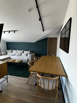 a living room with a table and a couch at Уютни планински апартаменти с басейн в комплекс Алпин Лодж in Bansko