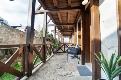 a porch of a house with a chair on it at Green Life Cozy Studio Bansko in Bansko