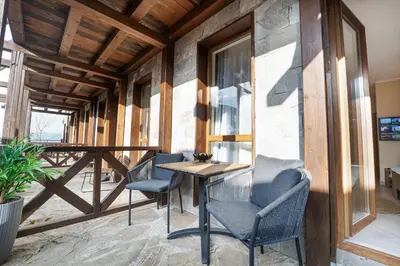 a patio with chairs and a table on a porch at Green Life Cozy Studio Bansko in Bansko