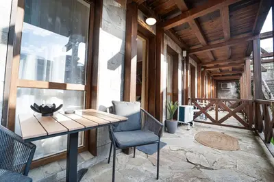 a patio with a wooden table and chairs on a porch at Green Life Cozy Studio Bansko in Bansko