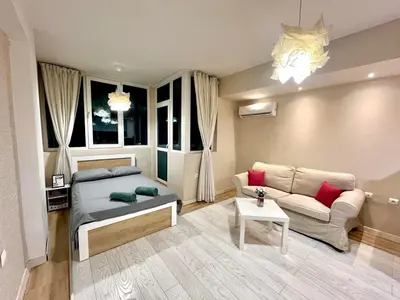 a living room with a bed and a couch at Winter Palace Vitosha View Studio in Sofia