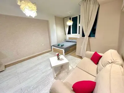 a living room with a couch and a table at Winter Palace Vitosha View Studio in Sofia