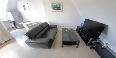 a living room with a black leather couch and a flat screen tv at Spacious Penthouse Sofia in Sofia