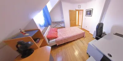 a small room with a bed and a desk at Spacious Penthouse Sofia in Sofia