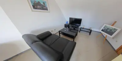 a living room with a black couch and a table at Spacious Penthouse Sofia in Sofia