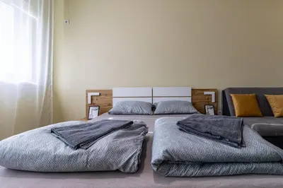 two beds sitting in a room with a couch at Ishirkov Residence Studio in Sofia