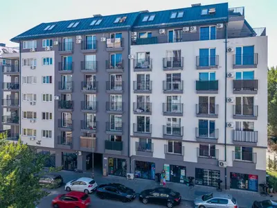 a large white building with cars parked in a parking lot at Ishirkov Residence Studio in Sofia