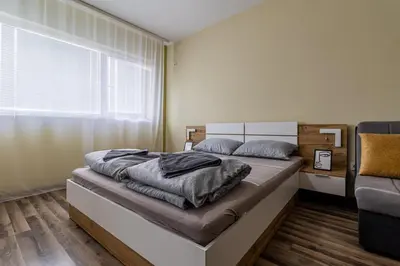 a bedroom with a bed and a couch and a window at Ishirkov Residence Studio in Sofia