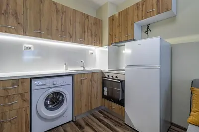 a kitchen with a white refrigerator and a dishwasher at Ishirkov Residence One Bedroom Apartment in Sofia