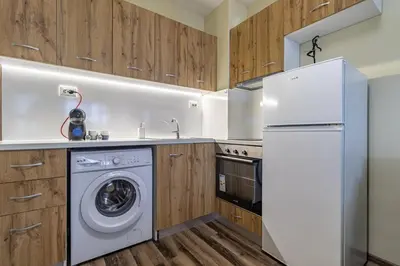 a kitchen with a washing machine and a refrigerator at Ishirkov Residence One Bedroom Apartment in Sofia